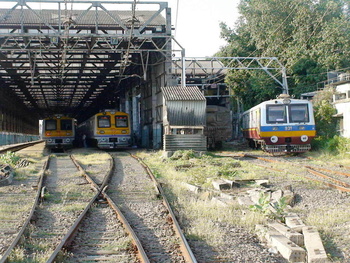 A view of Kandivali Car Shed with two Mrvc Emu's and a motorman coach of the Millenium/9xx series Ac - Dc emu undergoing POH. (A