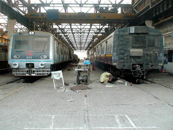 9xx series emu# 955 motorman coach and a Millenuium emu coach to be lifted up shortly by the machine. (Arzan Kotval)