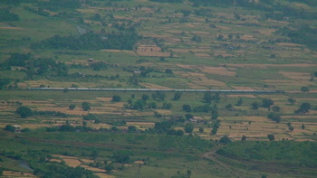 A panoramic view of Neral – Bhivpuri road section capturing an entire train, shot from Dastur point, Matheran located at a heigh